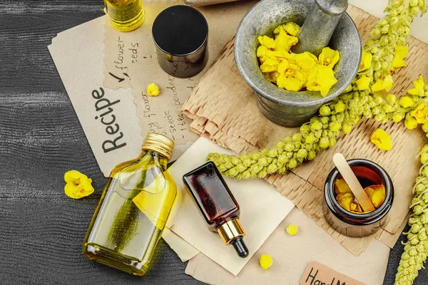 Verbascum çiçekleriyle doğal cilt bakımı, yağlar, kremler ve güzellik tedavileri için bitkisel malzeme. Siyah ahşap arkaplan, üst manzara