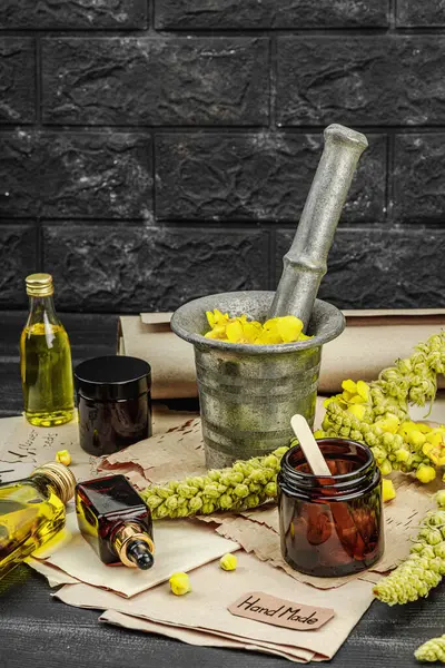 Verbascum çiçekleriyle doğal cilt bakımı, yağlar, kremler ve güzellik tedavileri için bitkisel malzeme. Siyah tahta arkaplan, boşluğu kopyala