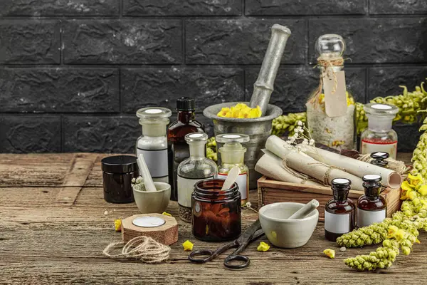 Verbascum çiçekleri, bitkisel kavanozlar, antika aletler ve ahşap masada havan topuyla kırsal eczacılık sahnesi. Alternatif tıp, sağlıklı yaşam tarzı konsepti, kopyalama alanı