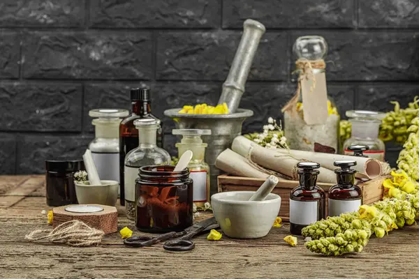 Verbascum çiçekleri, bitkisel kavanozlar, antika aletler ve ahşap masada havan topuyla kırsal eczacılık sahnesi. Alternatif tıp, sağlıklı yaşam tarzı konsepti, kopyalama alanı