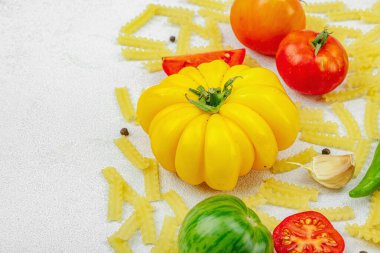Çeşit çeşit domates, sarımsak, biber ve baharatlı çiğ mafalda corta makarna. Çiftlikten sofraya konsept, sağlıklı ev yapımı sebzeler, düz yatak, kopyalama alanı