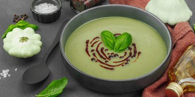 Fesleğen ve balzamik jöleli kremalı kabak çorbası taze malzemeler ve baharatlarla moda bir kasede servis ediliyor. Koyu taş arkaplan, pankart biçimi