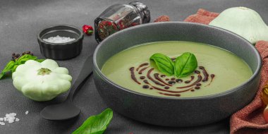 Fesleğen ve balzamik jöleli kremalı kabak çorbası taze malzemeler ve baharatlarla moda bir kasede servis ediliyor. Koyu taş arkaplan, pankart biçimi