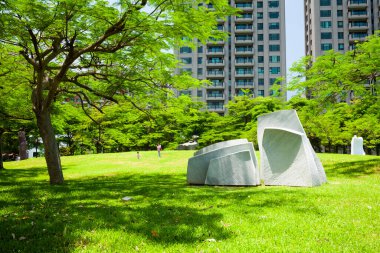 Parkta mavi gökyüzü olan yemyeşil ağaçlar, Kaohsiung Güzel Sanatlar Müzesi, Tayvan 'daki heykel parkı..