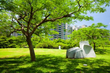 Parkta mavi gökyüzü olan yemyeşil ağaçlar, Kaohsiung Güzel Sanatlar Müzesi, Tayvan 'daki heykel parkı..