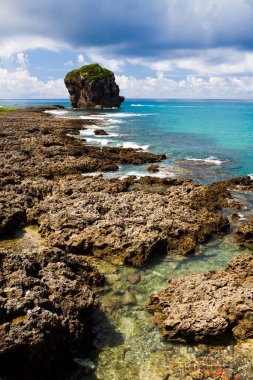 Pingtung, Tayvan 'daki Kenting Ulusal Parkı' nda Chuanfanshi kıyı resifleri ve gök mavisi gökyüzü dalgaları. Chuanfanshi Sahili, Tayvan 'ın Pingtung kentindeki Kenting Ulusal Parkı' nda yer almaktadır.. 