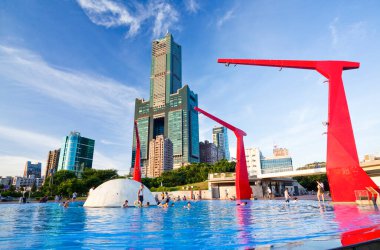 Turistler Kaohsiung, Tayvan 'daki Singuang Ferry Wharf' taki kırmızı çeşmede oynuyorlar. Kaohsiung Limanı 'nın 22. rıhtımının yakınlarında..