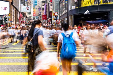 Merkez Bölge, Hong Kong, Çin 'deki ofis ve ticari binaların manzarası. Yayalar kavşakta karşıdan karşıya geçiyorlar..