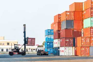 Tayvan, Taichung 'da bir konteynır deposunda bir istifçi kamyonlara konteynır koyuyor..