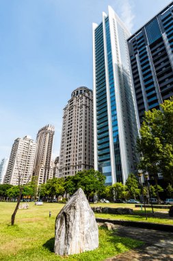 Tayvan 'ın Taichung şehrindeki yeşil park alanı ve modern binaların alçak açılı manzarası, Ulusal Taichung Tiyatrosu' na yakındır..