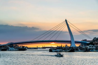 New Taipei City, Tayvan 'daki Tamsui Balıkçı İskelesi' nde Aşıklar Köprüsü 'nün günbatımı manzarası. Beyaz kablolu bir köprü..