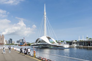 Kaohsiung, Tayvan - 9 Haziran 2022: Turistler Kaohsiung, Tayvan limanındaki Dagang Köprüsü 'nün (Büyük Liman Köprüsü) dönüşümlü sürecini izliyorlar.