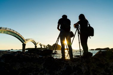 Photographer shooting a sunrise landscape at Sanxiantai Islet (Three Saints Island), East Coast National Scenic Area, Taitung, Taiwan. clipart