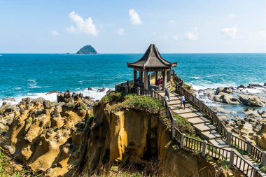 Keelung City, Tayvan - 17 Eylül 2022: Turistler Keelung, Tayvan 'daki Heping Adası Parkı' ndaki Sahilsel Pavyon 'dan kayalık kıyı manzarasını ziyaret ediyorlar..