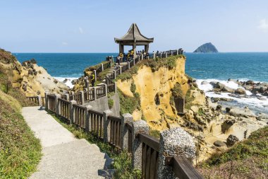 Keelung City, Tayvan - 17 Eylül 2022: Turistler Keelung, Tayvan 'daki Heping Adası Parkı' ndaki Sahilsel Pavyon 'dan kayalık kıyı manzarasını ziyaret ediyorlar..
