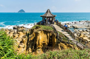 View of the rocky coastal landscape from the Scenic Pavilion at Heping Island Park in Keelung, Taiwan, with Keelung Islet just behind. clipart