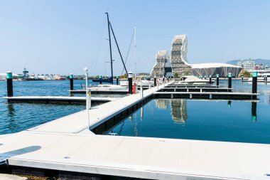 Kaohsiung, Tayvan... 24 Mart 2023: Kaohsiung Limanı 'ndaki Yacht Marina manzarası. Kaohsiung Müzik Merkezi binasıyla..