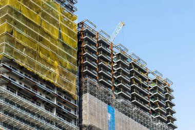 Binanın çelik yapılarının düşük açılı görüntüsü mavi gökyüzü arka planına sahip..