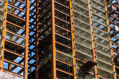 Binanın çelik yapılarının düşük açılı görüntüsü mavi gökyüzü arka planına sahip..