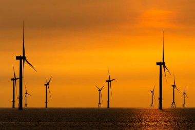 Tayvan 'ın batı kıyısındaki Offshore rüzgar güç sistemlerinin gün batımı görüntüsü.