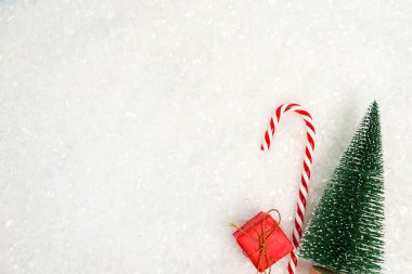 Kırmızı hediye kutusu, şeker ve Noel ağacı olan karlı bir Noel arkaplanı. Boşluğu kopyala