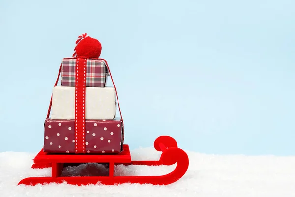 赤いそりにギフトボックス付きのクリスマスブルーの背景 コピースペース — ストック写真