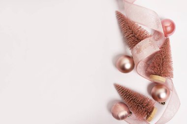 Pembe Noel ağaçları ve süs eşyaları beyaz arka planda fotokopi alanı ile birlikte. Yeni yıl tebrik kartı. Düz yatıyordu
