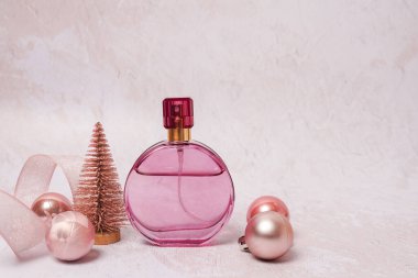 Açık beton arka planda parfüm şişesi olan Noel kompozisyonu