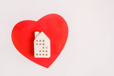Kırmızı kalpteki oyuncak ev beyaz arkaplanda kopya alanı ile
