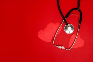 Red hearts with stethoscope on red background, heart health, health insurance concept, world health day, Valentine's day
