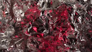 Crumpled foil texture with red lights, metallic shiny texture
