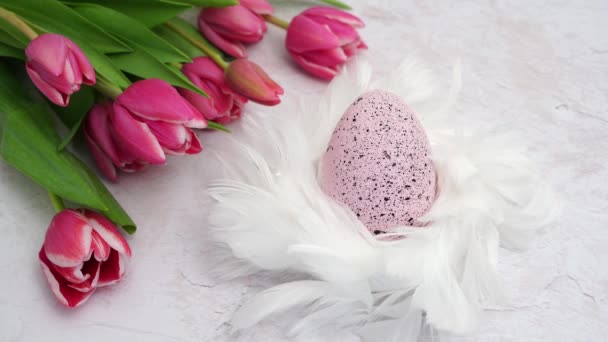 Easter Egg White Nest Feathers Pink Tulips White Background Wind — Stockvideo