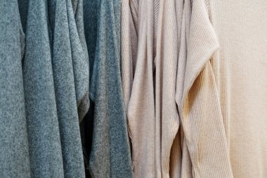beige and gray warm clothes in store, clothes background, winter sale