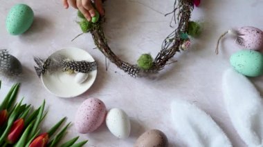 Paskalya çelengi yapan çocuk elleri. Paskalya bayramında renkli yumurtalardan yapılmış yaratıcı bir düzenleme. Dal parçalarından Paskalya çelengi. DIY ve yaratıcılık