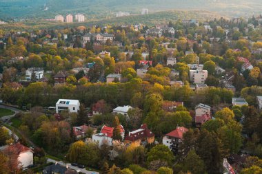 Sonbaharda şehir, kırmızı günbatımı efektleriyle arka plan, dağlardaki şehir