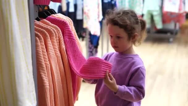 Cute Dziecko Dziewczyna Wybiera Ubrania Sklepie Ubraniami — Wideo stockowe