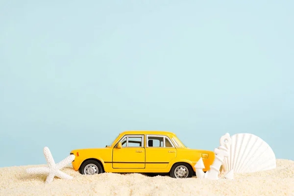 Speelgoedauto Met Schelpen Strand Zand Blauwe Achtergrond Taxiboekingsdienst Reizen Zomertijd Stockfoto