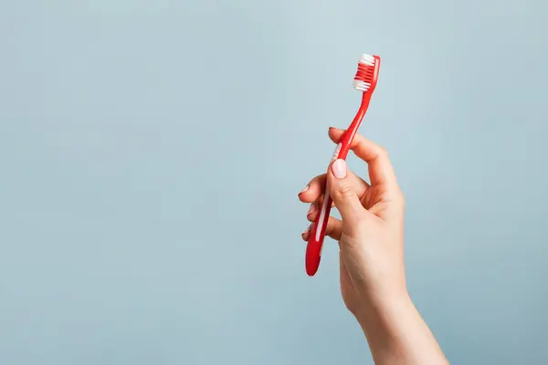 Mulher Segurando Escova Dentes Vermelha Contra Fundo Azul Cor Espaço — Fotografia de Stock