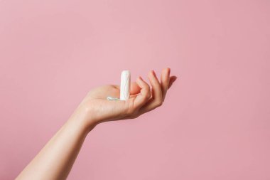 Pembe arka planda kadın eli olan bir tampon. Boşluğu kopyala