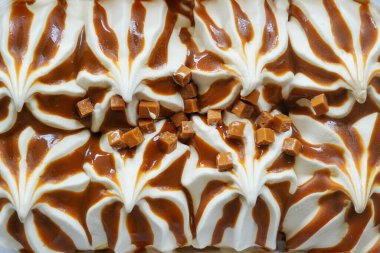 Karamelli dondurmanın beyaz yüzey dokusunu kapatın. Kahverengi çizgilerle kaplı..