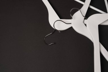 Siyah arka planda beyaz ahşap elbise askısı. Satış ve alışveriş konsepti. Kara Cuma. Boşluğu kopyala