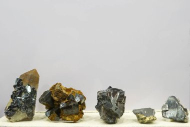 Gri arka planda çeşitli minerallerin toplanması: Cassiterite taşları