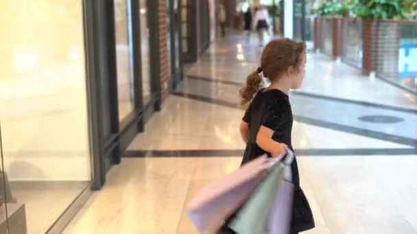 Szczęśliwe Dziecko Dziewczyna Czarnej Sukience Lubi Zakupy Dzieciak Torbami Zakupy — Wideo stockowe
