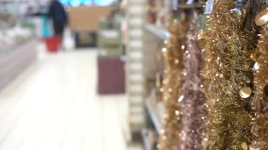 Alışveriş merkezinde renkli bir Noel çelengi yağmuru süsü. Mağazada yeni yıl dekorasyonu