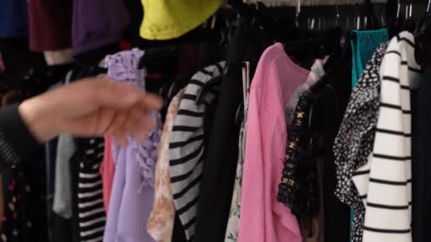 Kobieta Kupująca Używane Ubrania Drugiej Ręki Sklep Charytatywny Patrząc Różowy — Wideo stockowe
