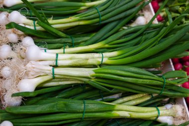 Marketteki kutuda taze toplanmış taze soğan yığını.