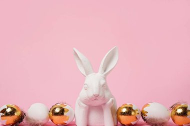 Beyaz tavşanlı ve altın yumurtalı Paskalya arkaplanı, kopyalama alanı. Paskalya tebrik kartı
