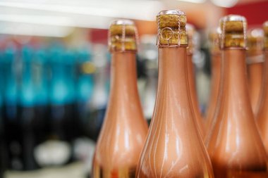 Altın şampanya şişeleri raflarda dizilmiş.