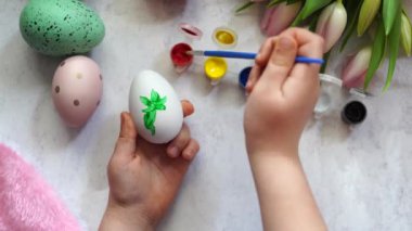 Paskalya yumurtasını boyayan çocuk, laleli ahşap masa