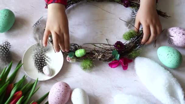 Dziecko Zdobi Wieniec Wielkanocny Ozdobnymi Jajkami Drewniany Stół Tulipanami — Wideo stockowe